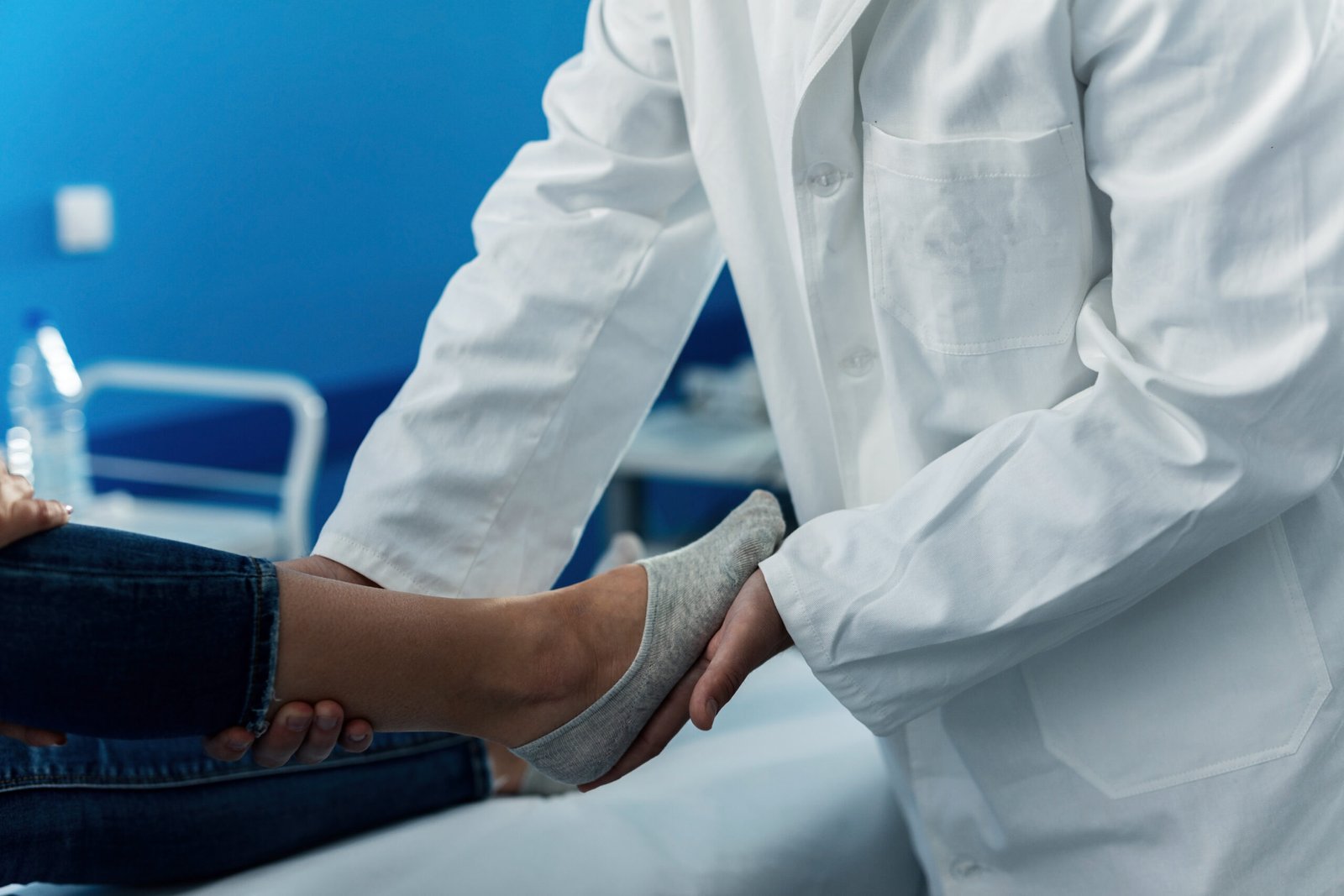 Close up of orthopedic examining foot of a woman at doctor's office.